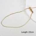 Flat lay of a golden 22cm adjustable chain anklet on a white textured background - Gold Adjustable Box Chain Bracelet 23cm