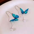 Macro view of butterfly earrings with blue gradient wings and dangling white pearls - Gradient Blue Butterfly Pearl Threader