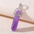 Macro detail of purple amethyst hexagonal crystal point with silver clasp on beige paper - Natural Amethyst