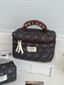 Detailansicht der gesteppten Cord-Kosmetiktasche mit Melody-Stickerei am Griff - Kosmetiktasche / Dunkelgrün
