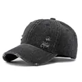 Distressed black denim baseball cap with vintage frayed holes and retro street style - Black