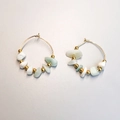 Detailed shot of golden hoop earrings featuring natural green and white stone chips - Amazonite