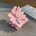 Dettaglio ravvicinato di una molletta per capelli a fiore rosa su uno sfondo minimalista - Rosa