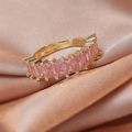 Macro view of adjustable gold ring featuring rectangular pink zircon stones on silk - Pink Rectangle Zircon/Row Ring