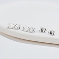 Orecchini a perno minimalisti in argento con scritta 'FUCK' su un vassoio bianco - Color Acciaio