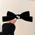 Elegant black velvet bow hair clip with white pearl accents held in hand - Bow Hair Clip (Pearl Decor) / Black