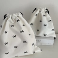 Minimalist white canvas drawstring bags with black ribbon bow print in two sizes - Large / Black