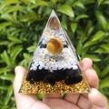 8cm Orgone Pyramid with obsidian, white crystal, and tiger eye stone sphere in hand - 8cm