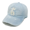 Dettaglio macro del cappello in denim slavato con ricamo della lettera H bianca sfrangiata - Stile Lettera H / Celeste