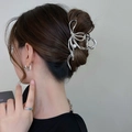 Detail of silver ribbon hair claw clip with pearl accent on a woman's styled hair - Silver Bow Style with Artificial Pearl (FJ2394)