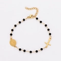 Detalle de pulsera de acero dorado con cruz, cuentas negras y colgante iconográfico - Dorado