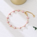Detail of gold evil eye bracelet with pink enamel beads and adjustable lobster clasp - Pink Eyes Gold