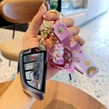 Cute purple liquid sand keychain featuring a cartoon cat pendant and rainbow hand strap - Purple-Lollipop Unicorn