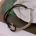 Détail du collier choker double rang avec perles noires, strass brillants et fermoir noué - Argenté