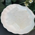 Translucent white crystal points displayed in a white seashell-shaped ceramic bowl - White Crystal