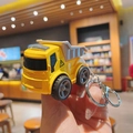 Macro detail of yellow cartoon dump truck keychain with metal ring and grey truck bed - Dump Truck