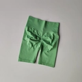 Detail of high-waisted seamless green yoga shorts featuring scrunch butt lifting texture - Green