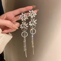 Close-up of silver tassel earrings with crystal flower charms and sparkling rhinestones - 47-Silver Pin-Silver-Flower Tassel