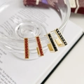 Elegant gold earrings with red and black gemstones displayed on glassware - Gold Red Zirconia (DEK586)