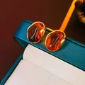 Detailed close-up of vintage geometric gold earrings with amber tiger eye resin inserts - No.3 Amber Organic Shape - Gold Plated (HE17330)