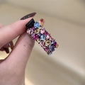 Gros plan d'une petite pince à cheveux noire avec des strass étincelants colorés - Rose Rouge Coloré