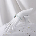 Light blue beaded bracelet with flower pendant on a white decorative plaster hand model - Pillar Hand