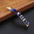 Close-up of golden hair clip with blue and white natural crystal stones on a dark surface - Blue Lace Agate Gold