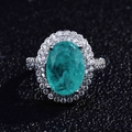Macro detail of oval Paraiba ring featuring double halo pave setting on black surface - Adjustable Open / Style C-Emerald Oval Double Halo