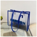 Détail d'un sac cabas en PVC bleu givré avec poignées en cuir et inscription de mode - Bleu