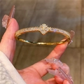 Elegante brazalete abierto dorado con amuleto de trébol de cuatro hojas con circonitas - Cuff Bracelet / Dorado