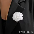 Detail of white fabric rose brooch with silk petals pinned on a black suit lapel - White