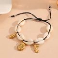 Detail of seashell woven bracelet with starfish, seahorse and nautilus golden charms - Black Rope Conch Bracelet