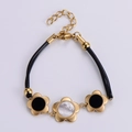 Bracciale a fiori in acciaio placcato oro 18k con cordino nero e madreperla - Oro