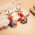 Detail of starfish earrings with red beads and colorful fish pendants on a stone surface - Stainless Steel Pin Red Fish