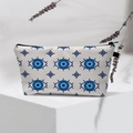 Detail showing Evil Eye pattern cosmetic bag with black zipper on geometric stand - Light Blue Evil Eye