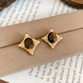 Detalle de pendientes retro en forma de estrella con piedra de ojo de tigre y base dorada - Marrón dorado