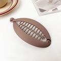 Detail shot of brown matte banana hair clip with non-slip teeth on a white surface - Matte Mocha