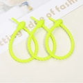 Close-up of three neon green adjustable silicone cable ties with non-slip tooth design - Jelly Yellow