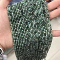 Faceted green natural gemstone beads held in hand showing small size and cut texture - Emerald (Natural Style) 3mm