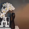 Nordic black twisted ceramic vase with orchids and frame on a textured tabletop - Swan Neck Vase Tall Black