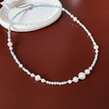 Dettaglio della collana di perle e turchese con chiusura in argento su sfondo rosso - Collana-Bianco