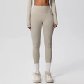 Detail van naadloze high-waist yogabroek in licht havergrijs met een brede tailleband - Kameelbruin