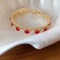 Dettaglio del bracciale aperto in oro con zirconi rossi e bianchi nella conchiglia - Stile Aperto (HB482) / Oro Rosso