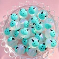 Gros plan de perles lumineuses de 16 mm en forme de vache bleue dans un plat - Petit Monstre Vert / 16mm Lumineux