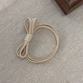 Beige ribbed fabric hair scrunchie with cute bowknot detail on a rustic linen background - Beige