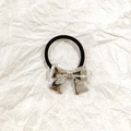 Silver metallic bow hair tie with high elastic black band on white textured background - Silver Butterfly 4cm