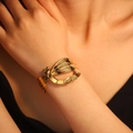 Elegant gold dragonfly cuff bracelet with hollowed wings on a model's wrist - Dragonfly Design