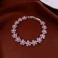 Detailaufnahme eines rosa Zirkonia Blumenarmbands auf dunkelbraunem Seidengrund - Silber-Rosa (Blume)