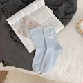 Light blue mid-calf socks with white ribbon bows displayed on a vintage book - One Size / Light Blue with Double White Bows