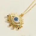 Detailed macro view of gold evil eye sun pendant with colorful zircons and blue bead center - Eyelash Design 2